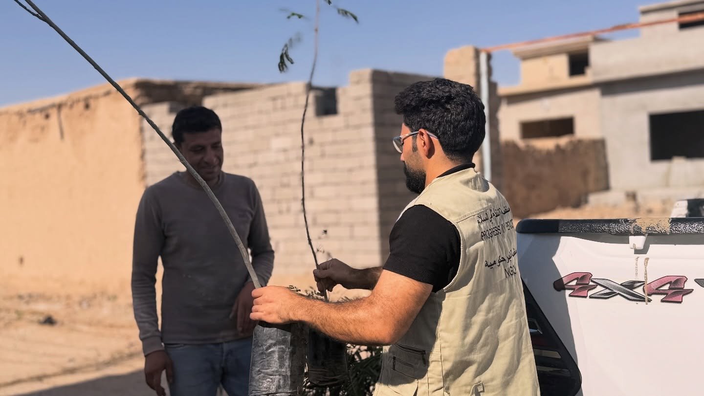 Volunteers and families planting trees in Til Banat, Sinjar